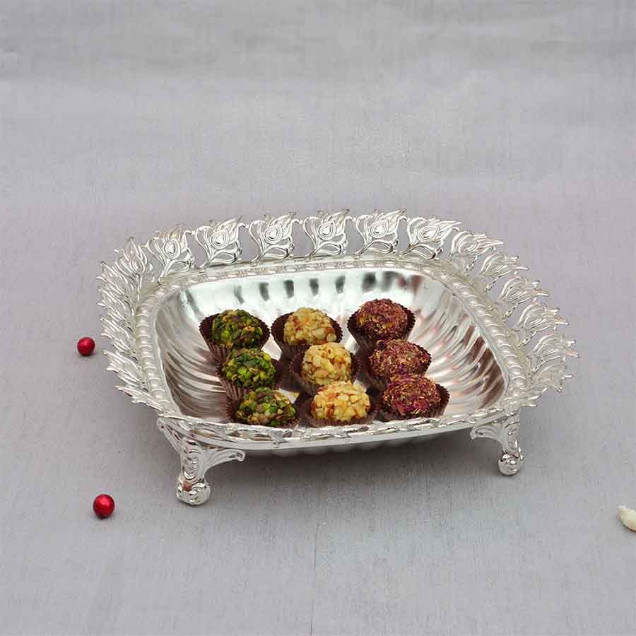 Chocolates in square silver plated tray with inticate cut-work border